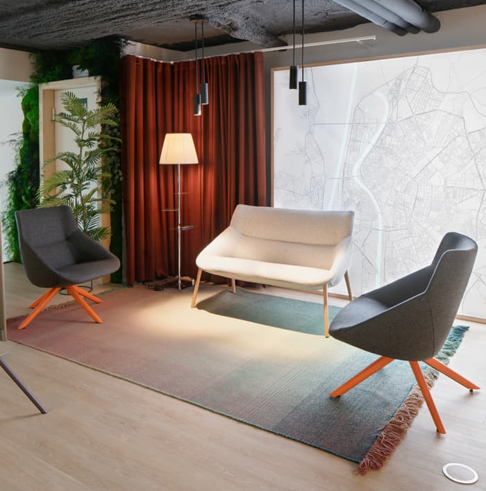 Espacio lounge en oficina con asientos grises
